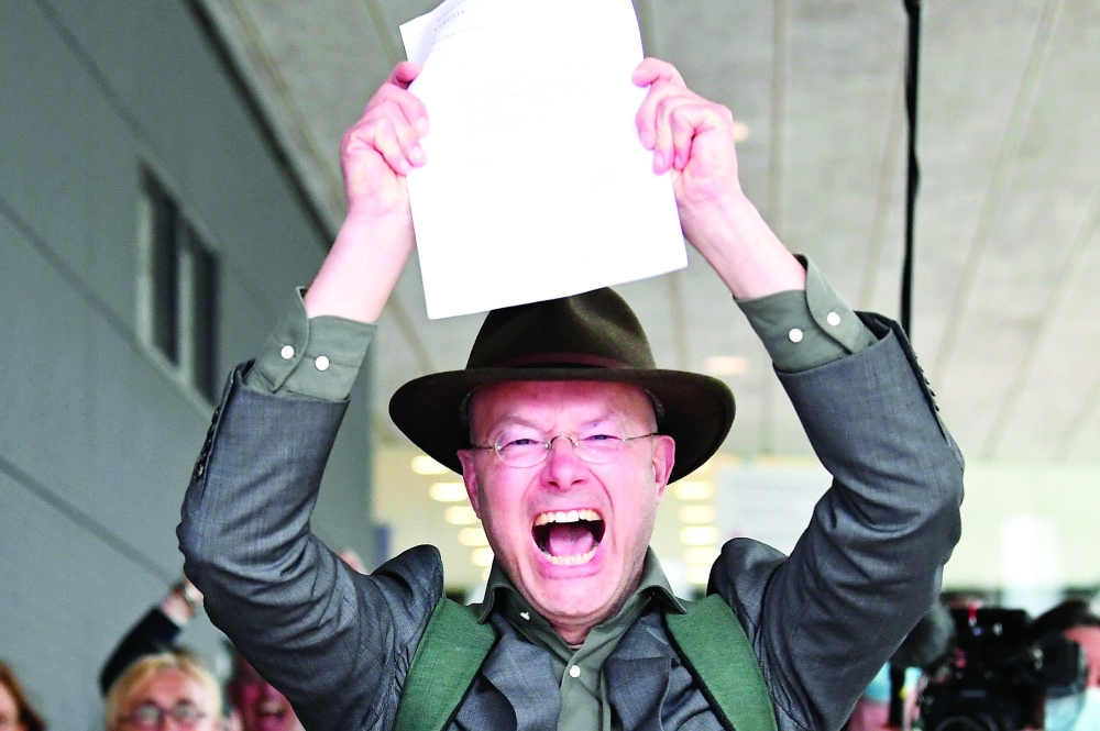 Donald Pols, Director of Milieudefensie, reacts holding a copy of a verdict in a case brought on against Shell by environmentalist and human rights groups, who demand the energy firm cuts its reliance on fossil fuels, in The Hague, Netherlands. - Reuters 