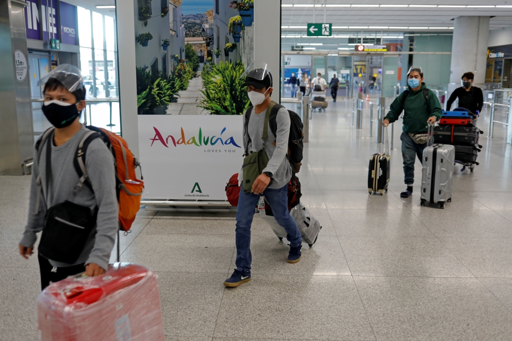 Tourists wearing face masks and face shields as protection against the coronavirus disease arriving from the Philippines. 