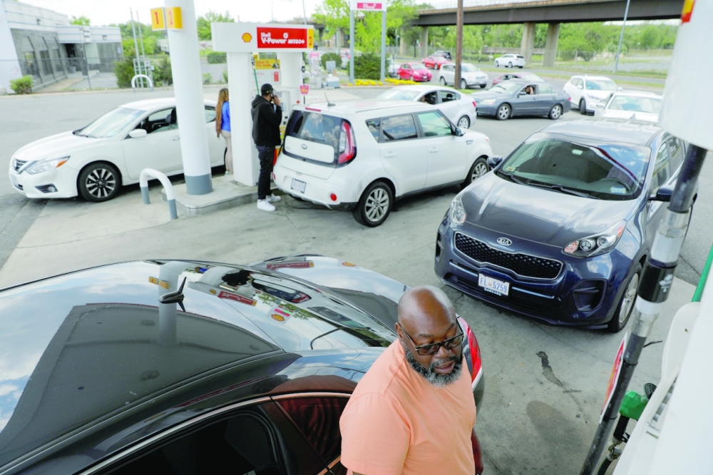 A person fills their car with gas as people queue at a Shell gas station, after a cyberattack crippled the biggest fuel pipeline in the country, run by Colonial Pipeline, in Washington, DC. - Reuters
