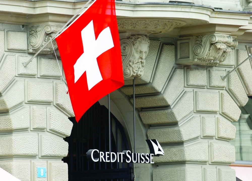 Switzerland's national flag flies above the logo of Swiss bank Credit Suisse at its headquarters in Zurich. - Reuters File Photo