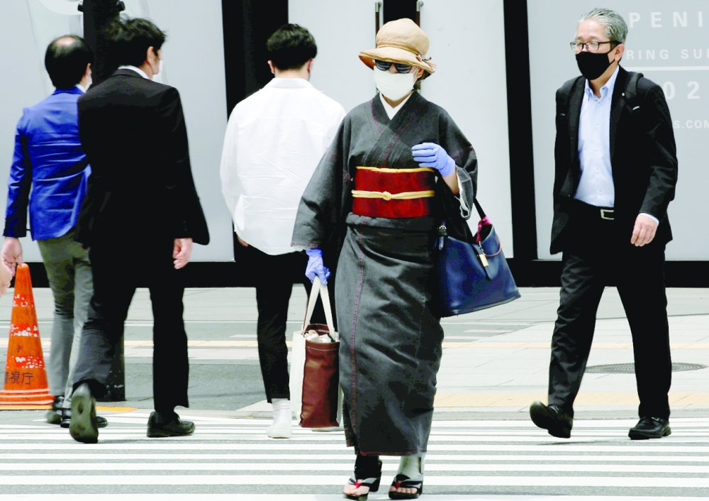 A Kimono-clad woman wearing a protective mask and gloves, following the coronavirus disease outbreak, makes her way at a shopping district ahead of Tokyo 2020 Olympic Games in Tokyo. - Reuters