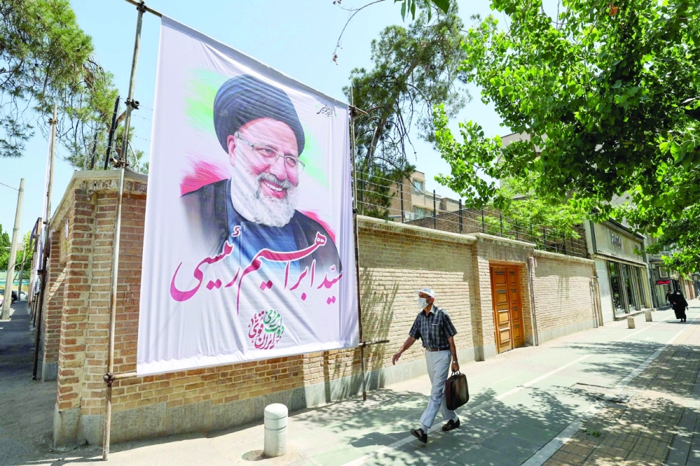 An Iranian man walks past an electoral poster depicting judiciary chief and presidential candidate Ebrahim Raisi in Tehran. - AFP
