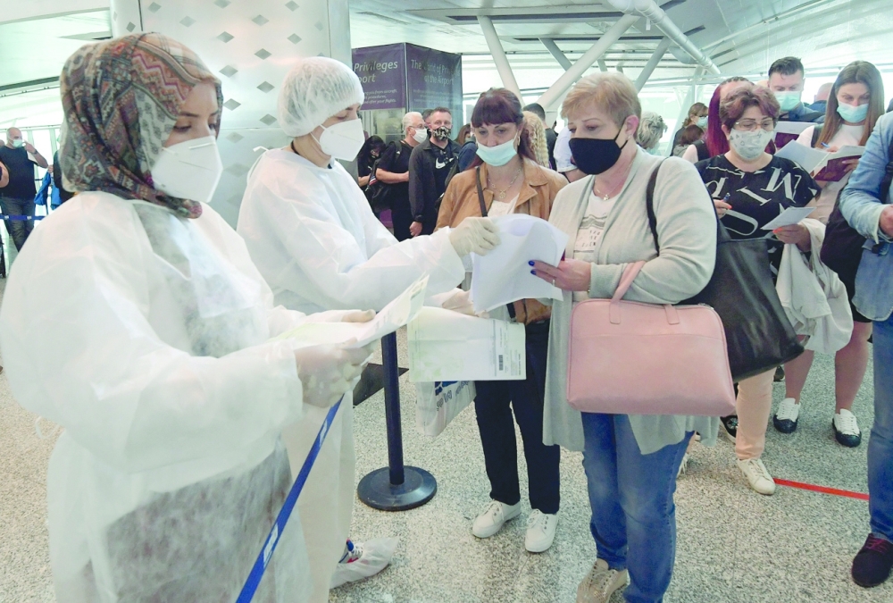 Tunisian health workers control European tourists upon their arrival at Enfidha-Hammamet International Airport near the Mediterranean town of Sousse. - AFP