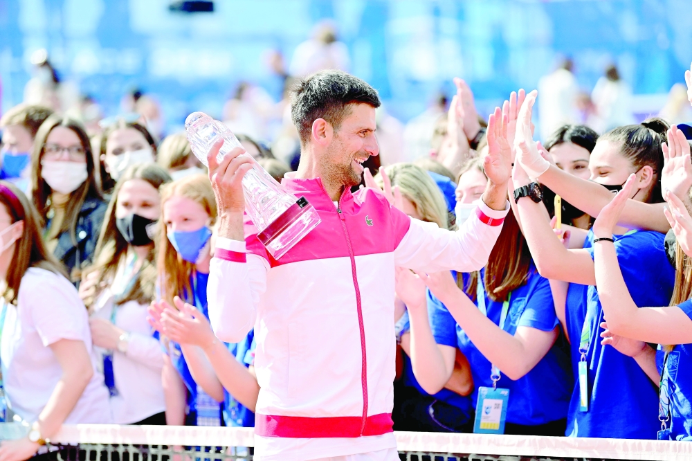 Serbia's Novak Djokovic claps hands with volunteers after winning the final against Slovakian Alex Molcan in Belgrade. -- AFP
