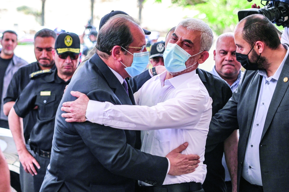 Yahya Sinwar (L), Hamas' political chief in Gaza, with General Abbas Kamel, Egypt's intelligence chief, as the latter arrives for a meeting with leaders of Hamas in Gaza City. - AFP 