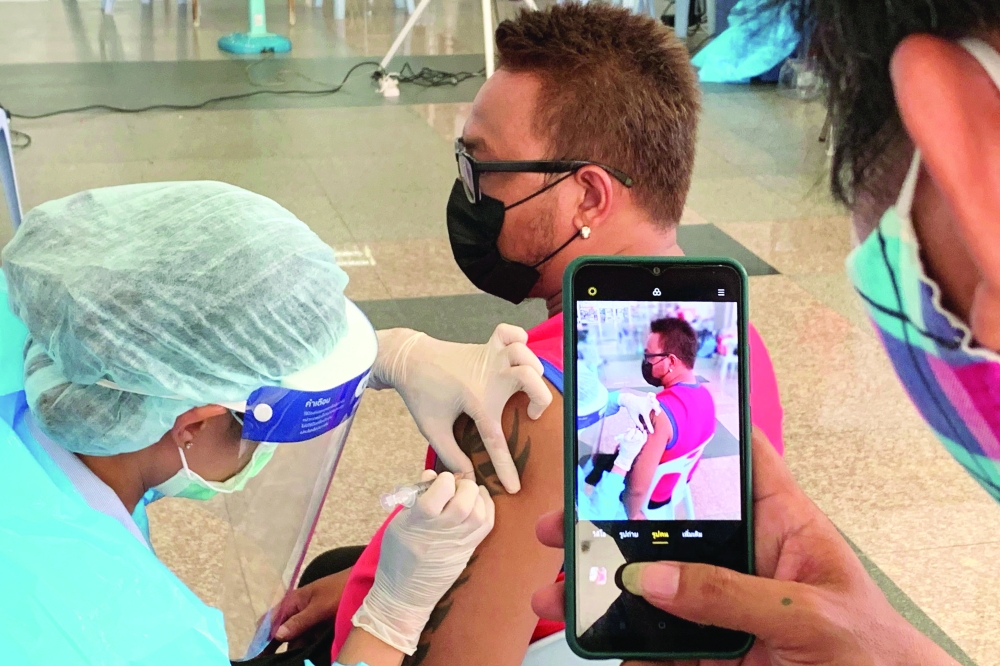 A health personnel inoculates a man with the second dose of China's Sinovac coronavirus vaccine in Bangkok. - AFP 