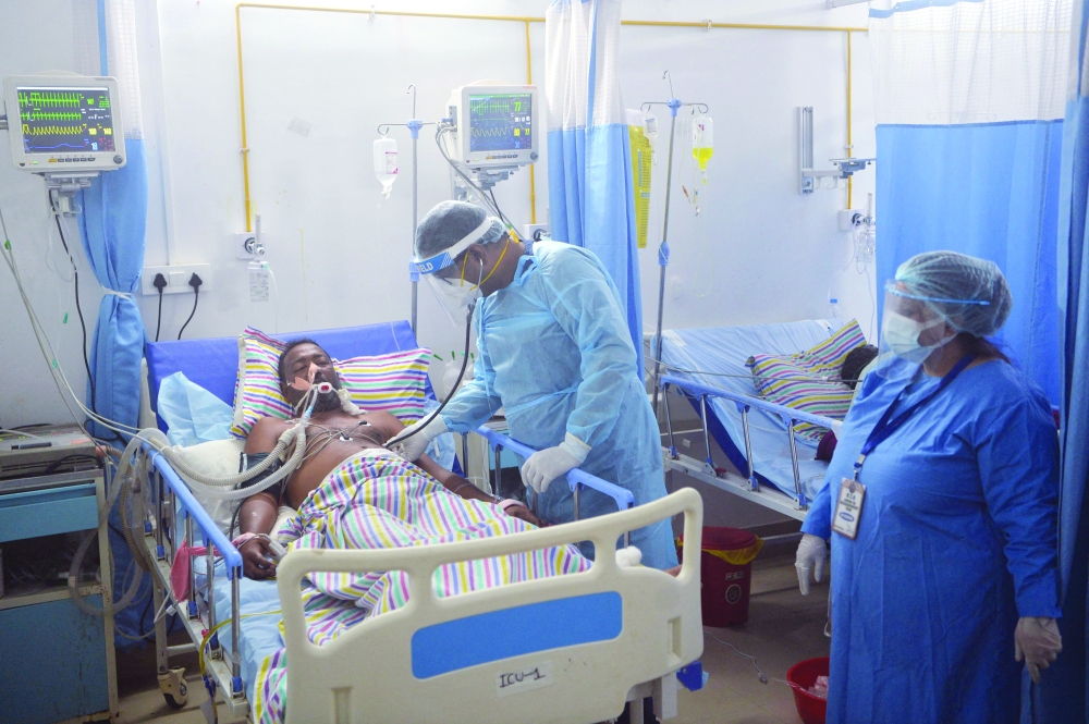 A doctor checks on a Covid-19 coronavirus patient at Intensive Care Unit (ICU) of a hospital in Siliguri on Tuesday. — AFP