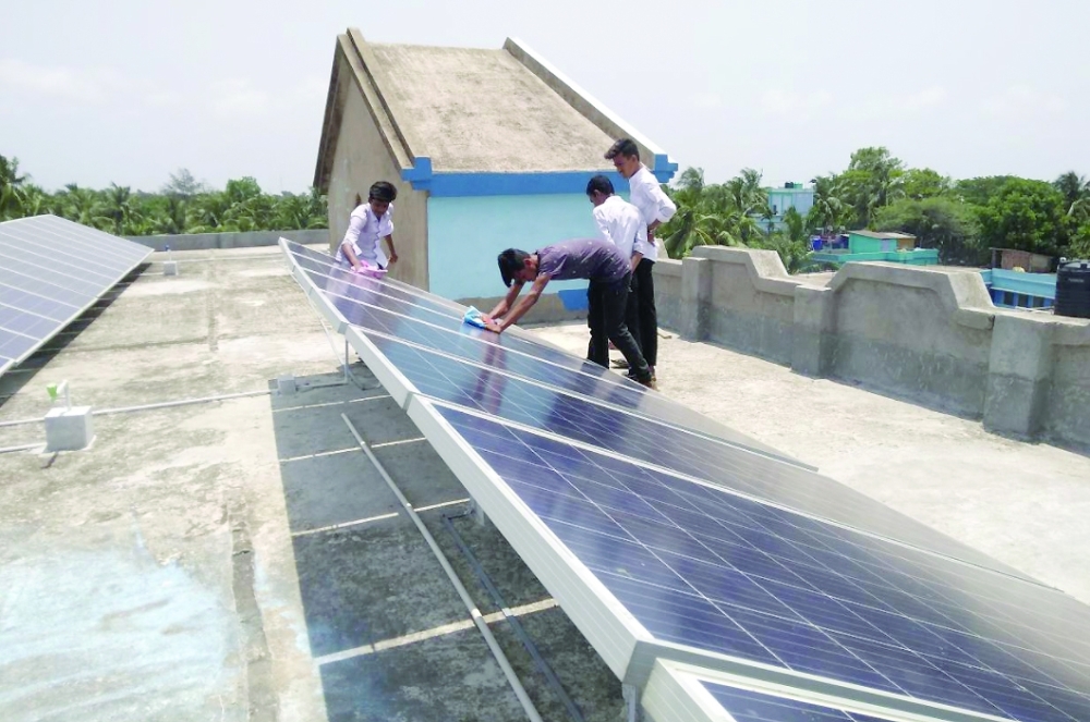 School students and staffs clean solar rooftop panels at the Akshaynagar Jnanadamoyee Vidyaniketan school in Kakdwip, West Bengal. - Reuters
