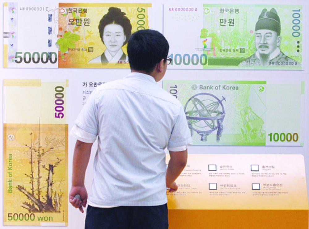 A student looks at oversized Korean won bank notes displayed inside Bank of Korea in Seoul, in this file photo. — Reuters