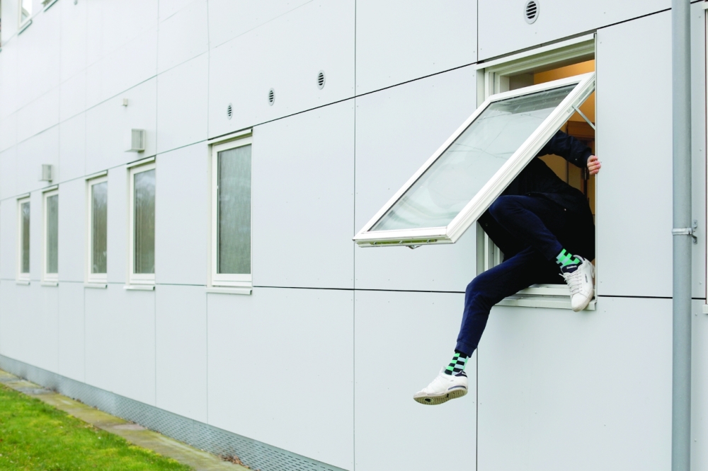 A resident climbs through a window at Kaershovedgaard, a former prison and now a departure centre for rejected asylum seekers in Jutland, Denmaark. —  Reuters file photo