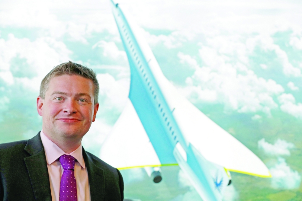 Boom Supersonic co-founder, Blake Scholl, poses in front of an artists impression of his company's proposed design for an supersonic aircraft, dubbed Baby Boom, at the Farnborough Airshow, southwest of London. - AFP