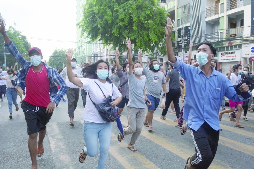 Anti-coup protesters flash the three-finger salute during a flash mob protest in Yangon. - Reuters