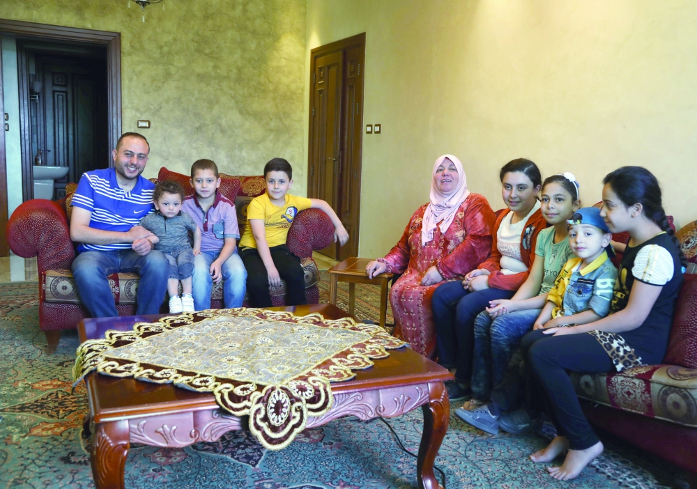 Abdullah Bashiti who recovered from coronavirus disease sits with his family at home in Amman. - Reuters 
