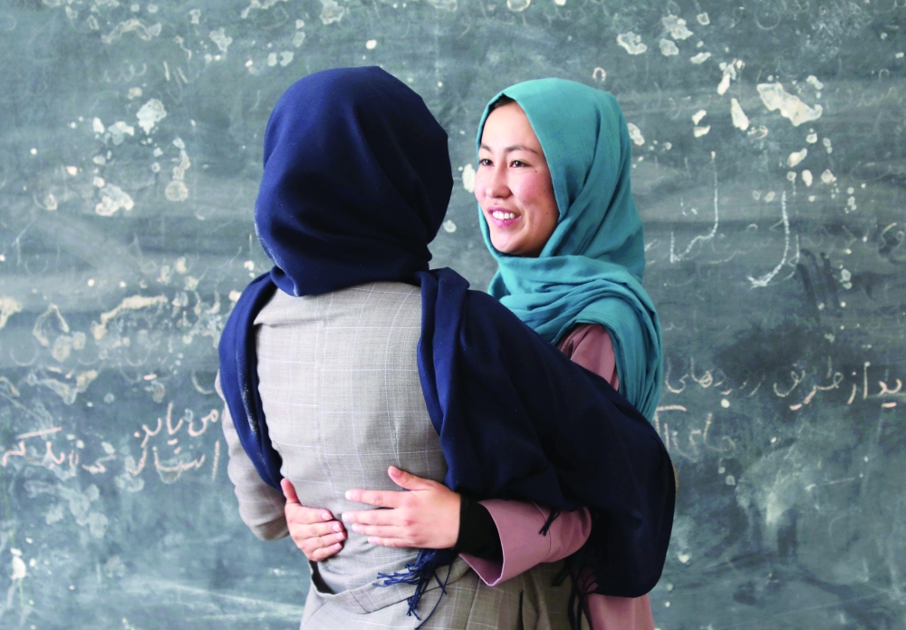 Fatima Noori hugs her friend as she arrives to attend psychotherapy class in Kabul. - Reuters 