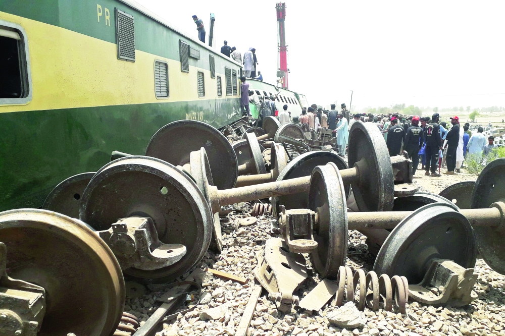 Security personnel and onlookers stand at the site of a train accident in Daharki area of the northern Sindh province. - AFP 