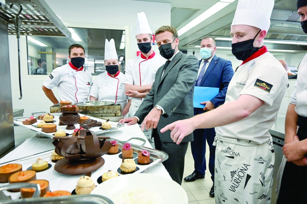Emmanuel Macron (C) talks with students, on June 8, 2021 in the kitchen of the Hospitality school in Tain-l'Hermitage, during a visit in Drome, the second stage of a nationwide tour ahead of next year's presidential election. — AFP