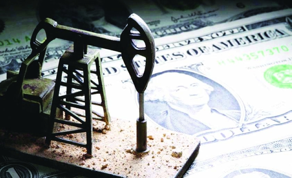 A 3D printed oil pump jack is placed on dollar banknotes in this illustration picture. — Reuters