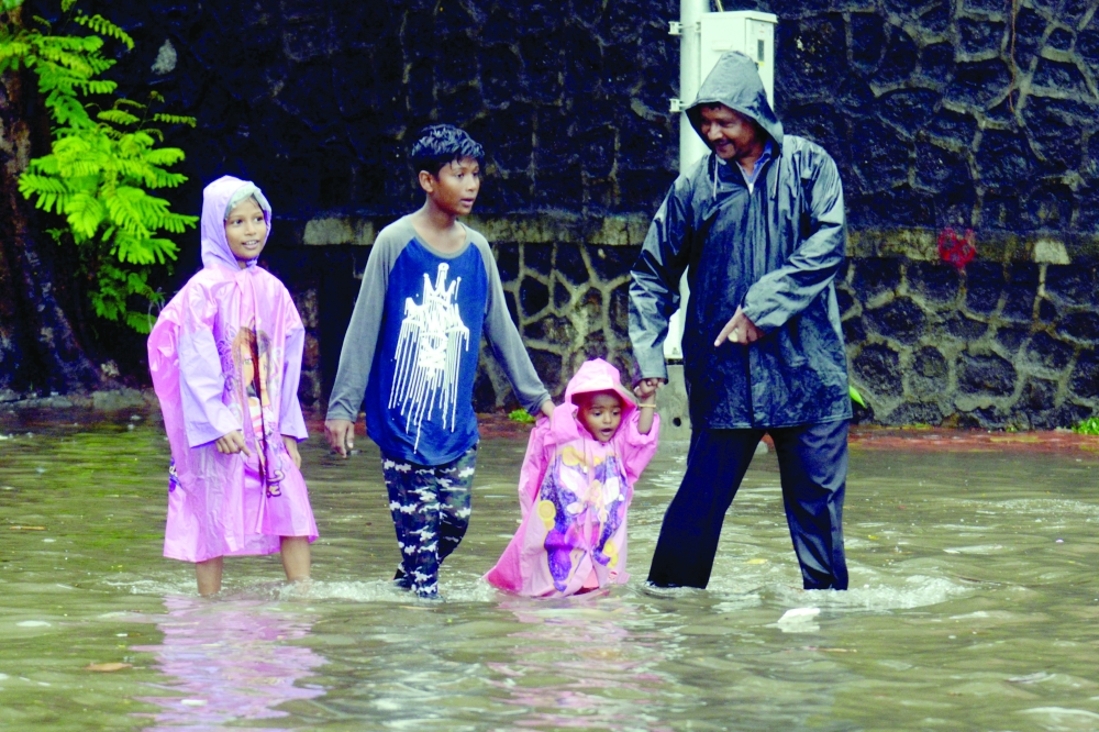 A family wades along a waterlogged street following a heavy monsoon rainfall in Mumbai on Wednesday. — AFP