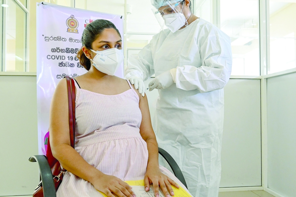 A health worker inoculates a pregnant woman with a dose of Sinopharm Covid-19 coronavirus vaccine in Colombo on Wednesday. — AFP
