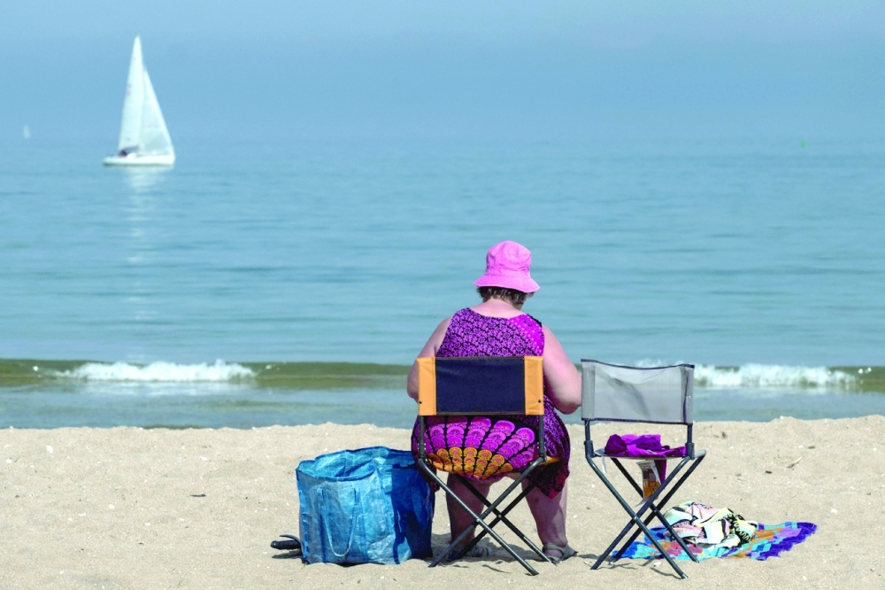A sunbather sits on the beach in Houlgate, northwestern France, on Wednesday. — AFP