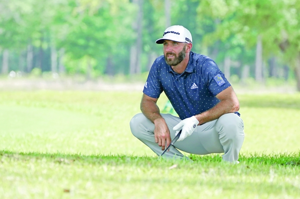 Dustin Johnson explores his options after hitting his ball into the trees on the eighth fairway during the first round of the Palmetto Championship. -- USA Today Sports
