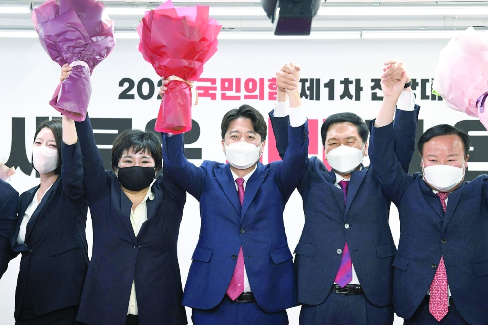 Lee Jun-seok (C), newly elected chairman of the main opposition People Power Party with new executive committee members at the party's headquarters in Seoul. - AFP
