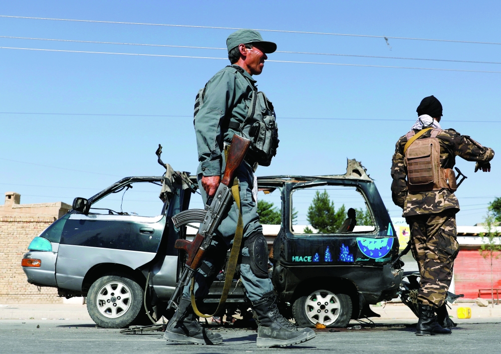 Afghan police officer inspects a damaged van after a blast in Kabul. - Reuters File Photo