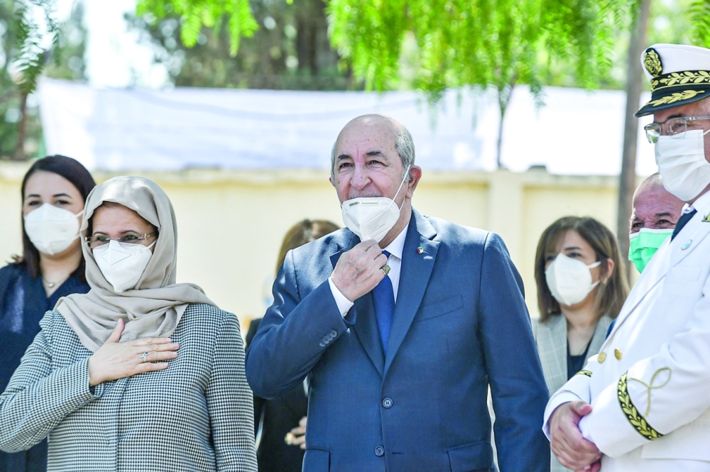 Algeria's President Abdelmadjid Tebboune arrives with his wife at a polling station in Bouchaoui, on the western outskirts of Algeria's capital Algiers. - AFP