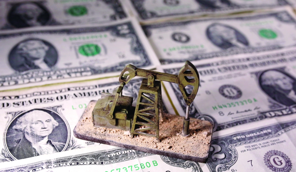 A 3D printed oil pump jack is placed on dollar banknotes in this illustration picture. — Reuters