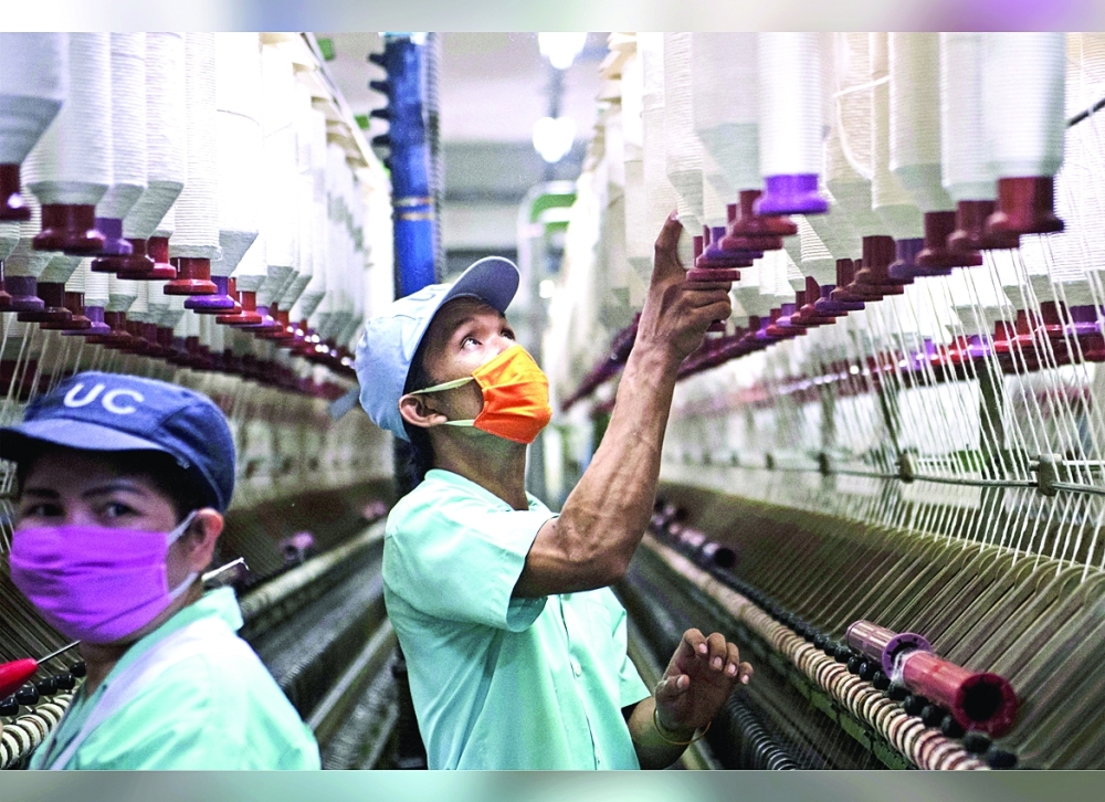 Workers are seen inside a textile factory in Pathum Thani province in Thailand. — AFP