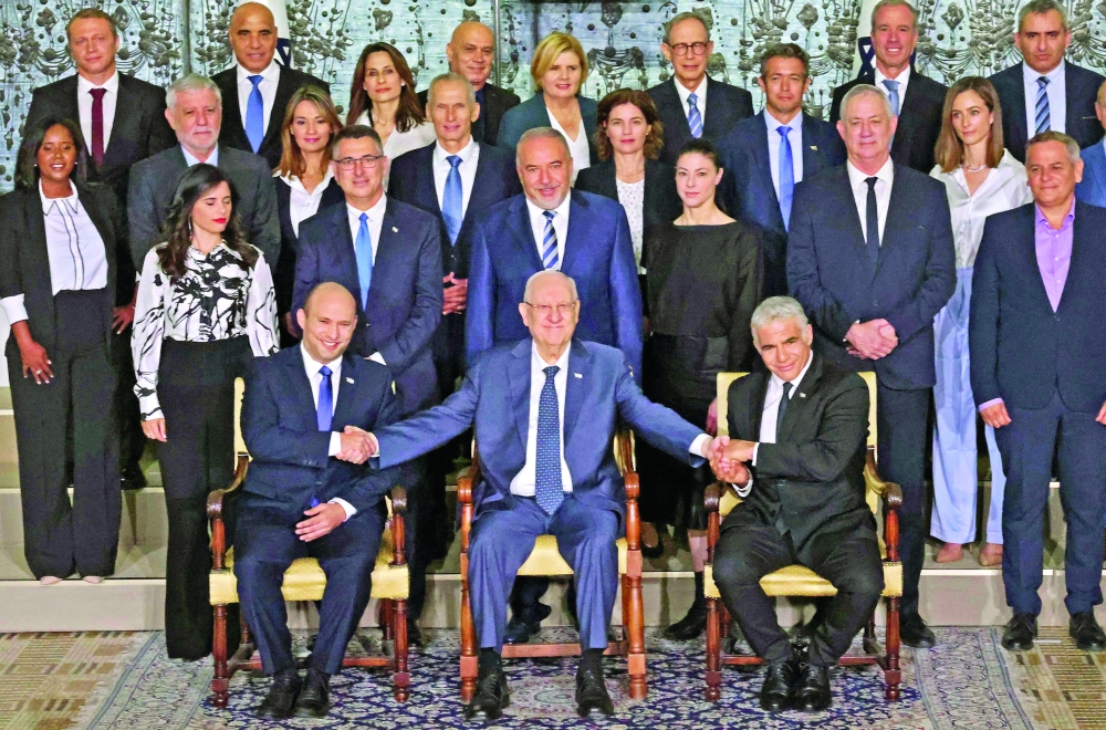 Outgoing Israeli President Reuvin Rivlin (C) is flanked by Prime Minister Naftali Bennett and alternate Prime Minister and Foreign Minister Yair Lapid during a photo with the new coalition government in Jerusalem. - AFP