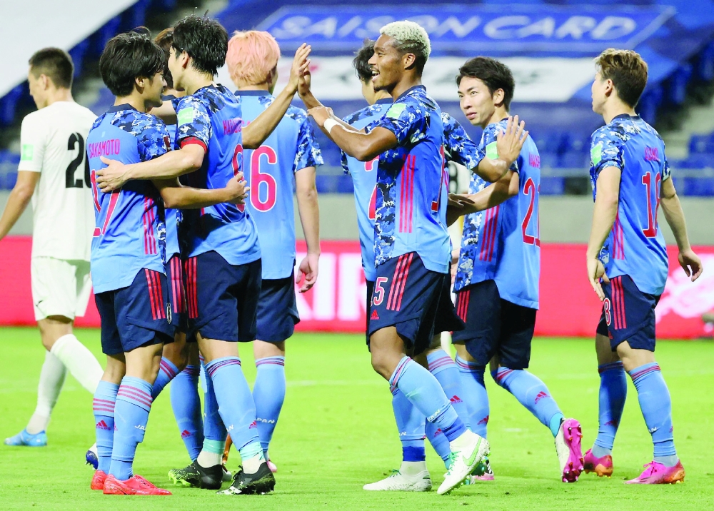 Japan's Ado Onaiwu (C) celebrates his goal with teammates. -- AFP