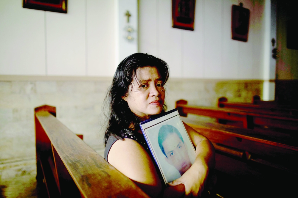 Normita Lopez, 56, is photographed while holding a portrait of her son Djastin Lopez, in a church nearby her home in
Manila on Tuesday. Lopez, whose son was a victim of the Philippines’ bloody narcotics campaign, is among the many
International Criminal Court (ICC) complainants calling for President Rodrigo Duterte’s international indictment over thousands
of alleged extrajudicial killings. — Reuters