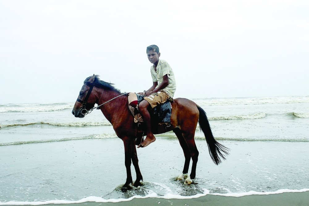 A youth rides a horse while he waits for customers along a beach in Cox’s Bazar on Wednesday. — AFP