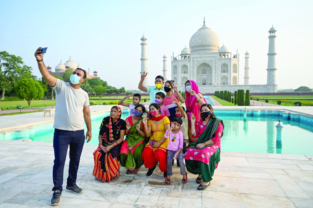 A group of tourists take photos at the Taj Mahal in Agra on Wednesday. — AFP