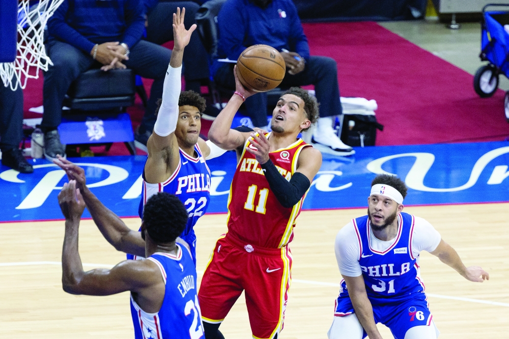 Atlanta Hawks' Trae Young (11) makes a basket against Philadelphia 76ers players at Wells Fargo Center. -- USA Today Sports