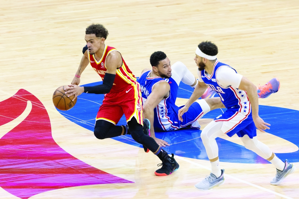 Atlanta Hawks' Trae Young (11) picks up a loose ball past Philadelphia 76ers' Ben Simmons (25) and Seth Curry (31). -- USA Today Sports