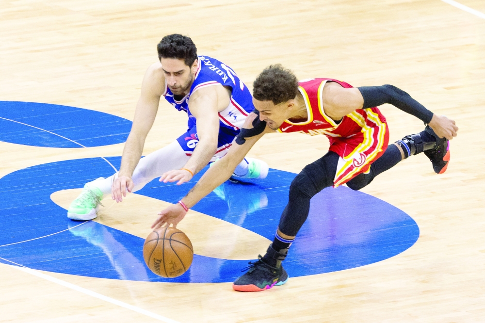 Atlanta Hawks' Trae Young (11) picks up a loose ball past Philadelphia 76ers' Furkan Korkmaz (30). -- USA Today Sports