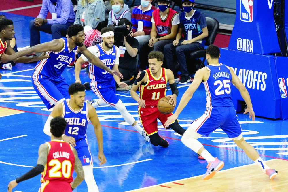 Atlanta Hawks' Trae Young (11) dribbles the ball in front of Philadelphia 76ers' Joel Embiid (21), Ben Simmons (25) and Seth Curry (31) at Wells Fargo Center. -- USA Today Sports
