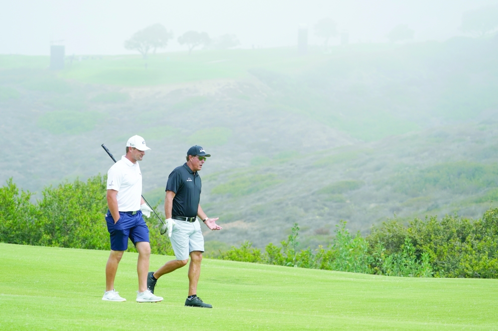 Bryson DeChambeau (left) and Phil Mickelson talk as they walk up the 13th fairway during a practice round of the US Open at Torrey Pines. -- USA Today Sports