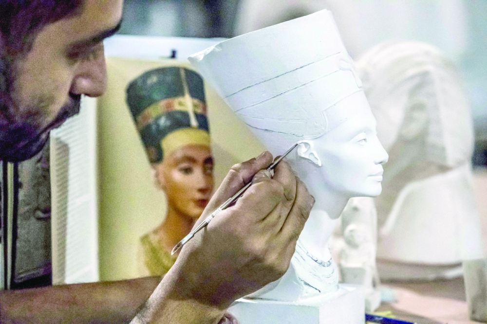 A technician crafts a replica of an Ancient Egyptian bust of Queen Nefertiti being fabricated at the Egyptian government factory reproducing replicas of Ancient Egyptian items, near Cairo. — AFP