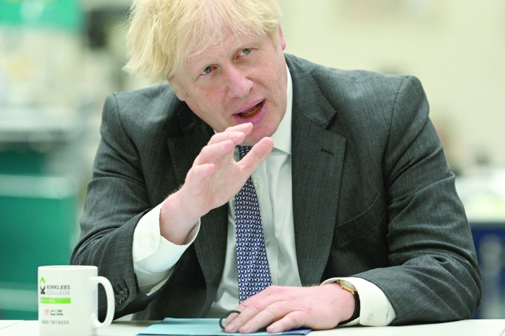 Britain's Prime Minister Boris Johnson chats with teachers in the Arts and Design area during a visit to Kirklees College Springfield Sixth Form Centre in Dewsbury, northern England. - AFP