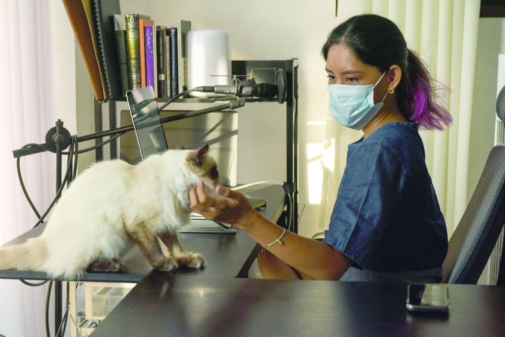 Tanya Mariano with her pet cat inside her hotel in San Juan town, north of Manila. - AFP 