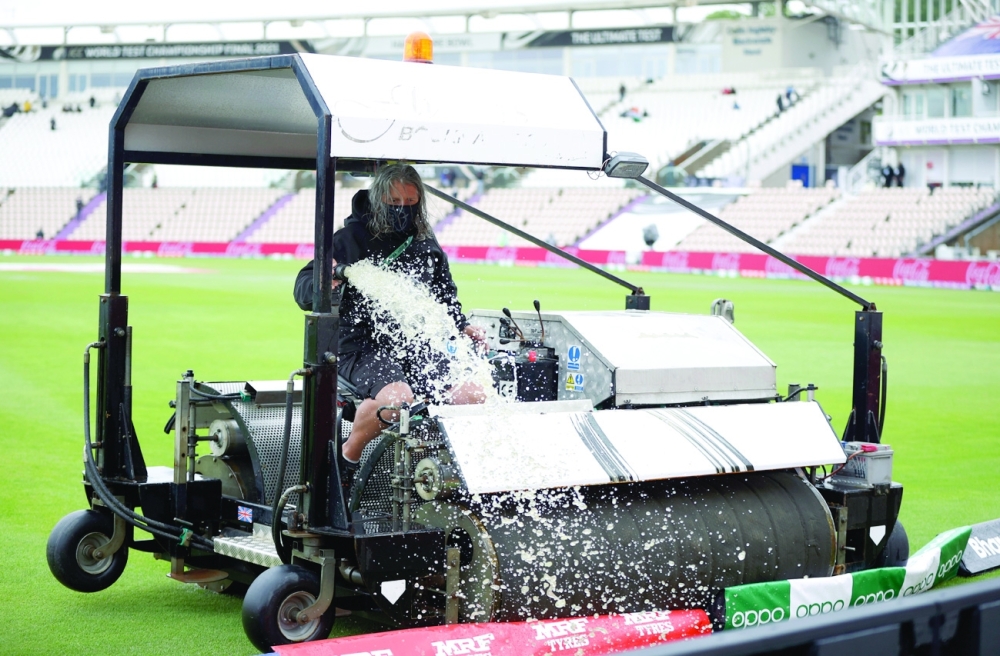 Ground staff clear water from the field. -- Reuters