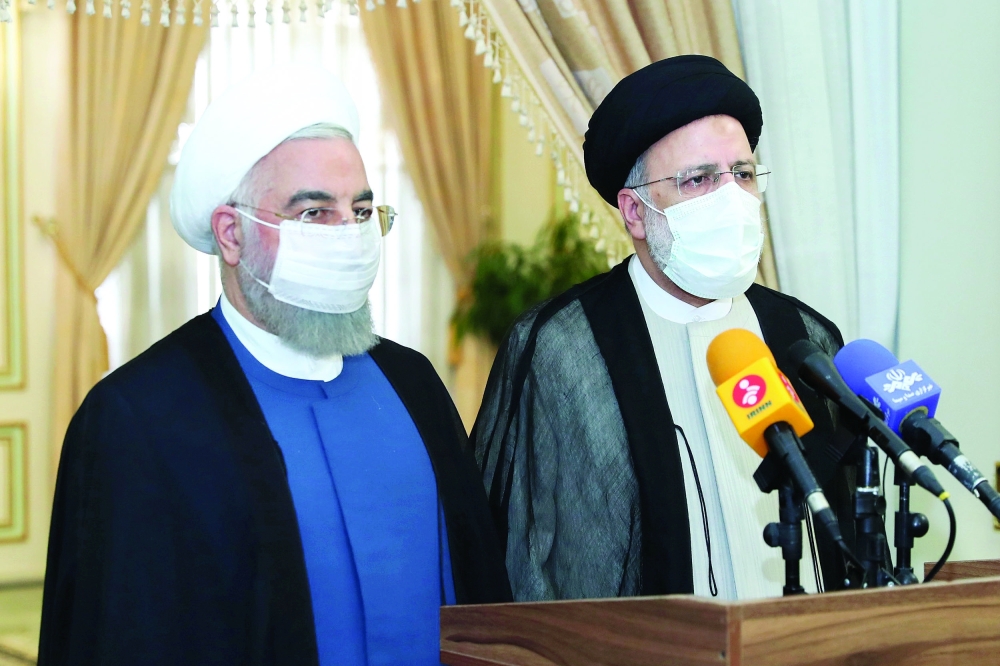 Iran’s outgoing President Hassan Rouhani and Iran’s President-elect Ebrahim Raisi speak to the media after their meeting in Tehran. — Reuters