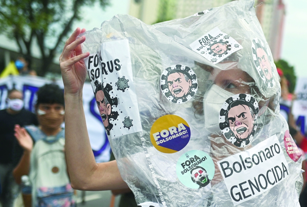 A demonstrator takes part in a protest against Brazilian President Jair Bolsonaro's handling of the Covid-19 pandemic in Rio de Janeiro, Brazil on Saturday. — AFP