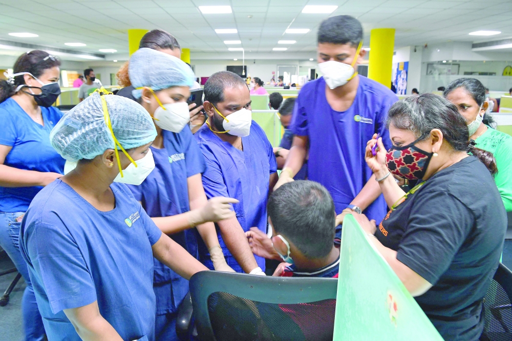 Multiple medical staff try to pacify a Person With Disability (PWD) who refused to get inoculated with the coronavirus vaccine during a special vaccination drive for differently abled people in Mumbai. - AFP 