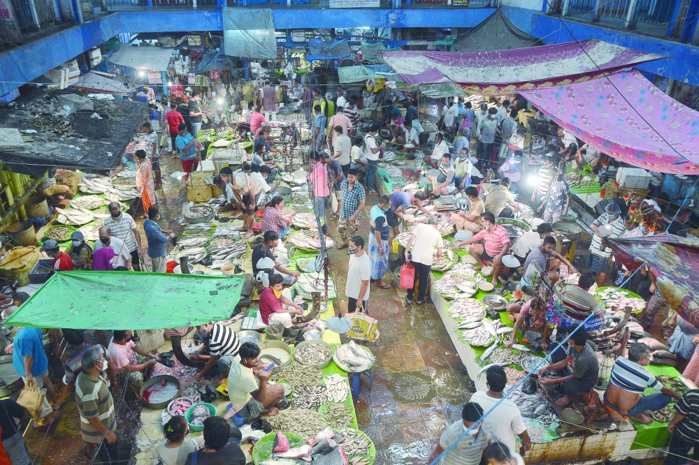 People shop at a fish market in Kolkata after West Bengal government eased lockdown restrictions to curb the spread of the coronavirus. - AFP 