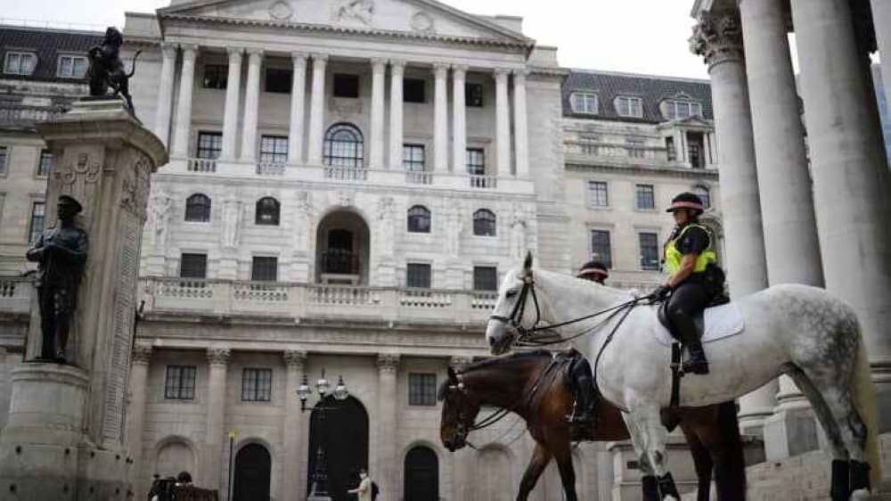Mounted police officers sit in outside the Royal Exchange and the Bank of England in London. — AFP