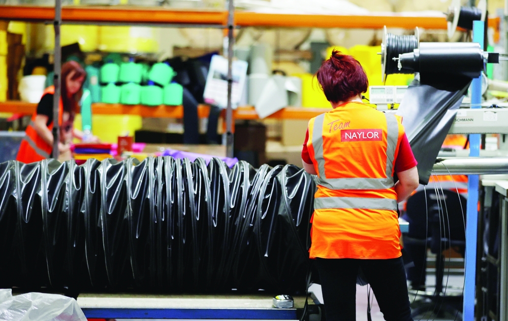 A worker constructs a length of ducting tube inside the Naylor Industries Wombwell site in Wombwell